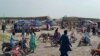 Local residents and ambulances gather beside carriages following the derailment of a passenger train in Nawabshah in the southern Sindh Province on August 6.