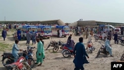 Local residents and ambulances gather beside carriages following the derailment of a passenger train in Nawabshah in the southern Sindh Province on August 6.