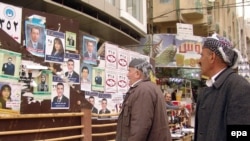 Ethnic Kurds read campaign posters of candidates on a street in Irbil, in northern Iraq.