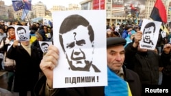 Protesters hold portraits of Ukrainian President Viktor Yanukovych during a demonstration in support of EU integration on Independence Square in Kyiv on November 29.