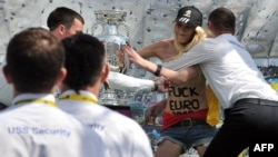 Security! Guards try to prevent topless Femen activist Yulia Kovpachyk from grabbing the Euro 2012 trophy in Kyiv on May 12.