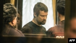 Jailed opposition activist Leonid Razvozzhayev stands inside a glass cage during a hearing of his case in a court in Moscow on February 18.