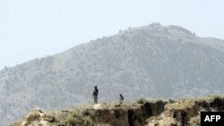 Pakistani soldiers stand guard on a mountain ridge in Pakistan's tribal district of Mohmand Hills.