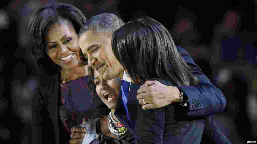 President Barack Obama hugs his daughters, Malia and Sasha, as First Lady Michelle Obama looks on during his election night victory rally in Chicago.