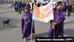 Young women carry a banner that reads, ''We Are Different -- We Are Equal'' as they participated in a rally to mark International Women's Day in Bishkek on March 8. The rally was later attacked by masked men.