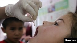 A girl receives a polio vaccine at the central hospital in the Tajik town of Tursunzade.