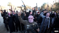 Masked Sunni gunmen shout slogans against the Iraqi Shi'a-led government during a protest in Fallujah on January 7.