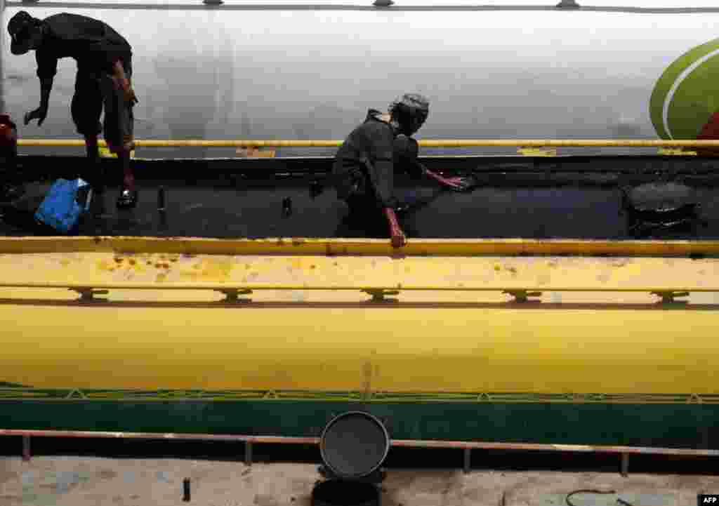 Laborers clean a tanker truck in Karachi ready to transport NATO goods on May 15.