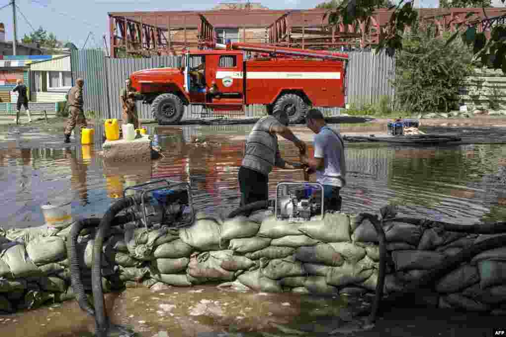 Workers for the Emergency Situations Ministry set up barriers on a flooded street in Khabarovsk on August 21.