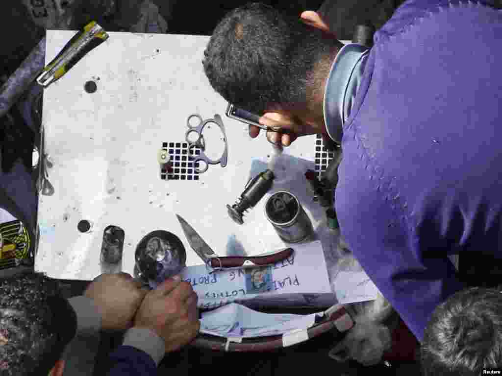 Antigovernment protesters show items they claim were taken from pro-government supporters at Tahrir Square.