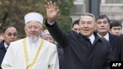 Kazakh President Nursultan Nazarbaev waves next to Absattar Derbisali, the supreme mufti of Kazakhstan, as he visits the Central Mosque in Almaty in November 2010.