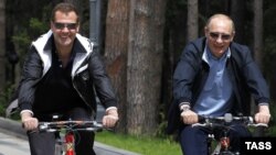 President Dmitry Medvedev and Prime Minister Vladimir Putin ride bicycles during an informal meeting at the Gorki residence outside Moscowon June 11.