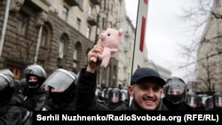 A protester with a toy pig in Kyiv