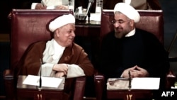 Former Iranian President Akbar Hashemi Rafsanjani (left) chats with current President Hassan Rohani during a session of the Assembly of Experts in Tehran on September 3.