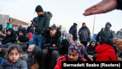 Migrants sit at the Serbian-Hungarian border as they protest to demand passage to the European Union, near Kelebija, Serbia, on February 6.