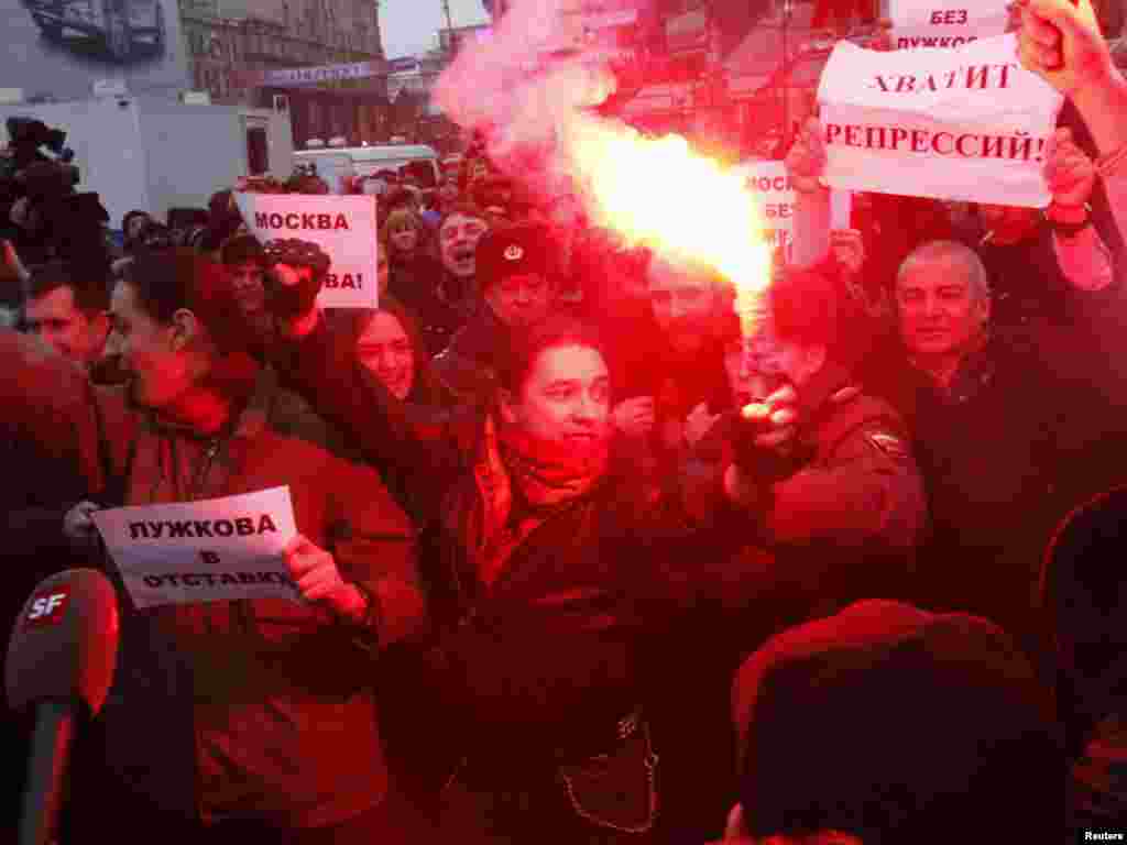 Opposition supporters light flares and shout slogans at an unsanctioned rally in Moscow.