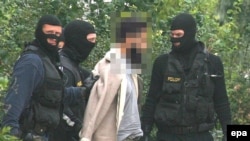 Police officers lead away a suspected terrorist in Vienna in September, 2007