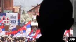 An ethnic Serbian boy looks at people demonstrating against the accord on the normalization of relations between Serbia and Kosovo in the ethnically divided town of Mitrovica on April 22.