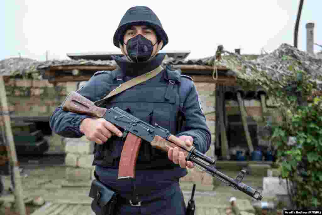 An Azerbaijani police officer stands near an abandoned Armenian artillery position in Fuzuli on November 18.