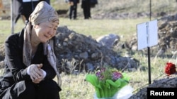 A woman mourns a victim of the violent revolt during a remembrance ceremony held at a cemetery in the village of Chon-Aryk.