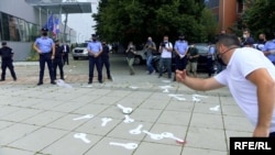 Protesters gathered outside the main government building in Pristina, where they threw away cardboard keys to symbolize the lost business they've suffered due to the restrictions.