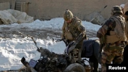 NATO troops investigate the the wreckage of a suicide bomber's car at the site of an attack in Kabul earlier this month.