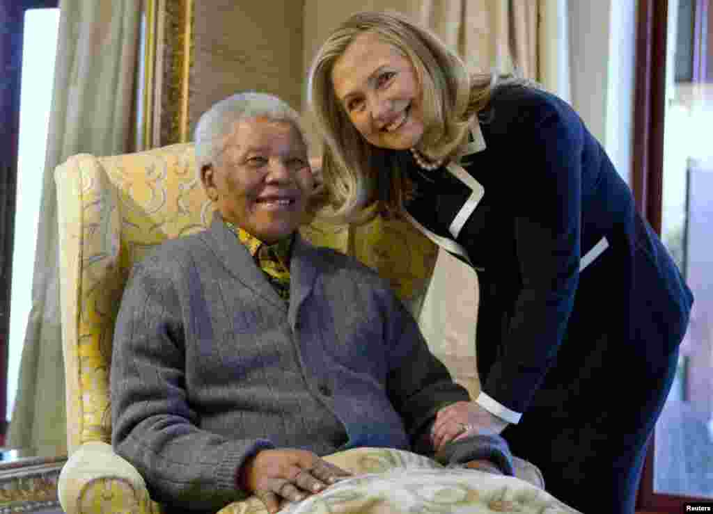 Secretary of State Hillary Clinton poses for a photograph with Nelson Mandela (left), former president of South Africa, at his home in Qunu on August 6, 2012.