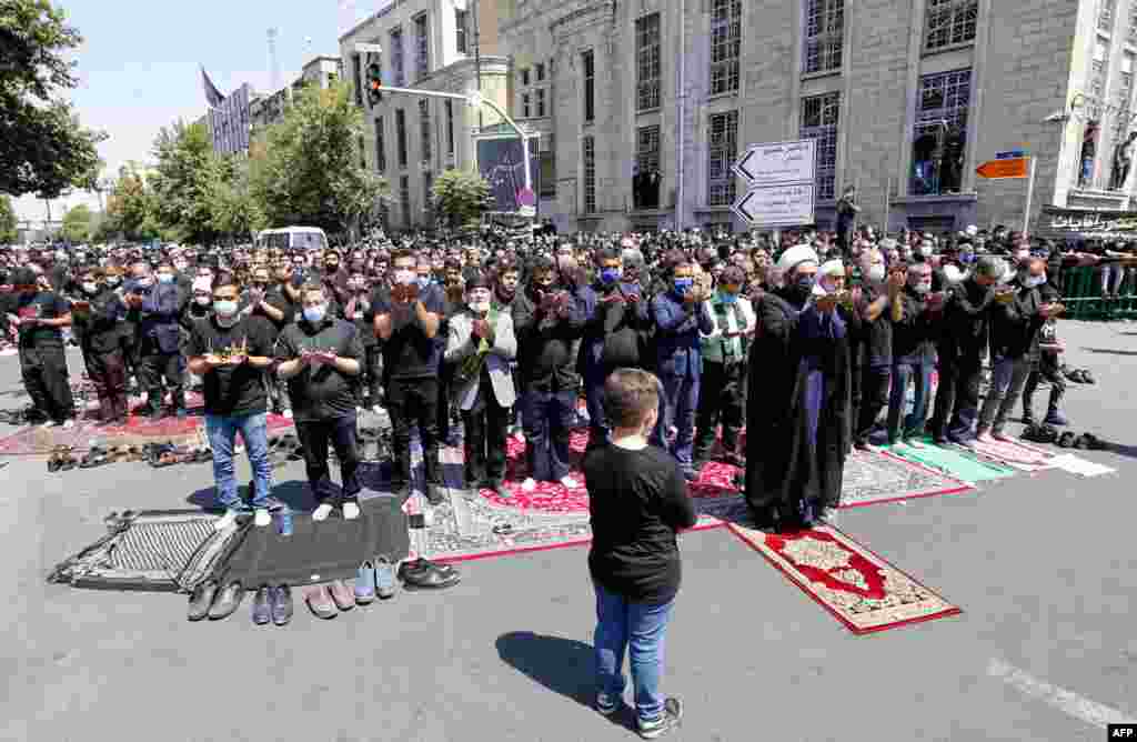 Iranian and Iraqi Shi&#39;a wear protective face masks during Ashura prayers in Tehran.