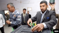 An electoral commission employee locks a ballot box at an Iraqi election center. (2009 file photo)