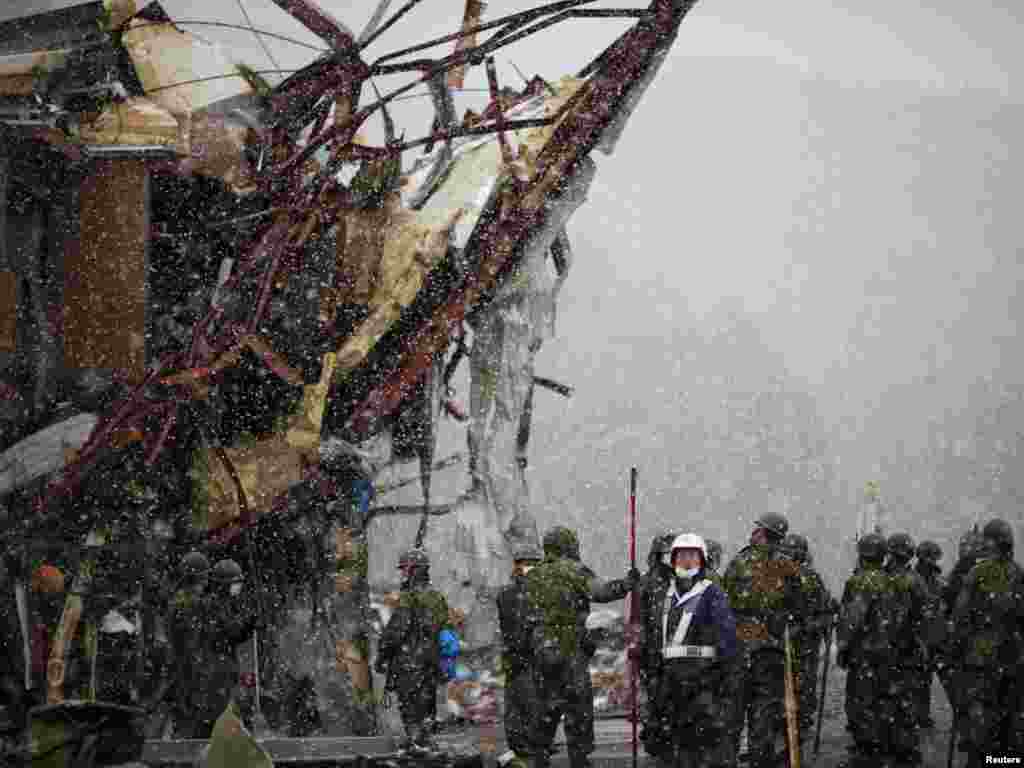 Heavy snow falls as members of the Japan Self-Defense Force arrive in Otsuchi on March 16