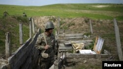 An ethnic Armenian soldier stands guard in a trench at artillery positions near the border with Nagorno-Karabakh (file photo from 2016)