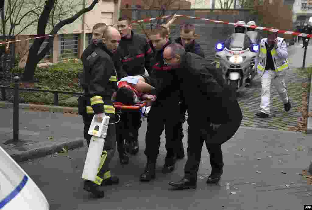 A victim is evacuated on a stretcher outside the publication&#39;s offices.