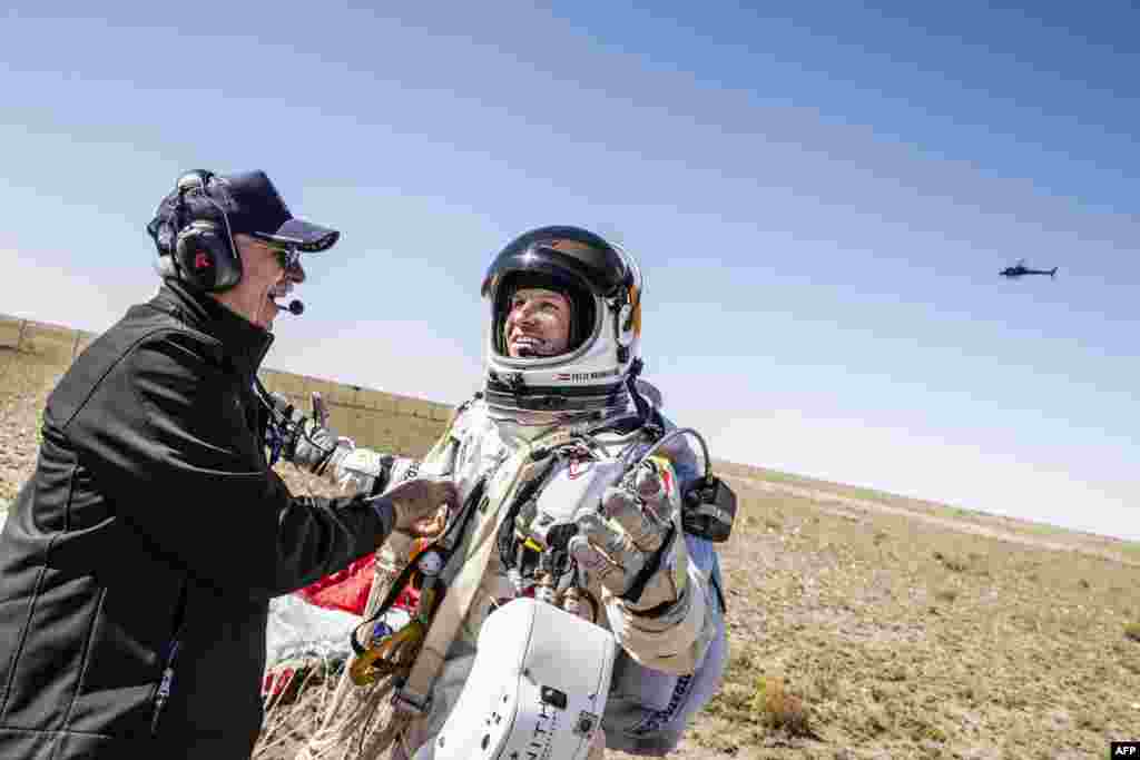 Life support engineer Mike Todd (left) greets Baumgartner after he landed safely.