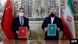 Iranian Foreign Minister Mohammad Javad Zarif (right) and his Chinese counterpart, Wang Yi, after signing a cooperation agreement in the capital, Tehran, on March 27