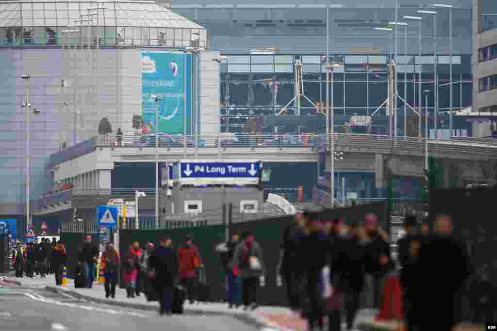 Passengers and airport staff are evacuated from the terminal building after the explosions.